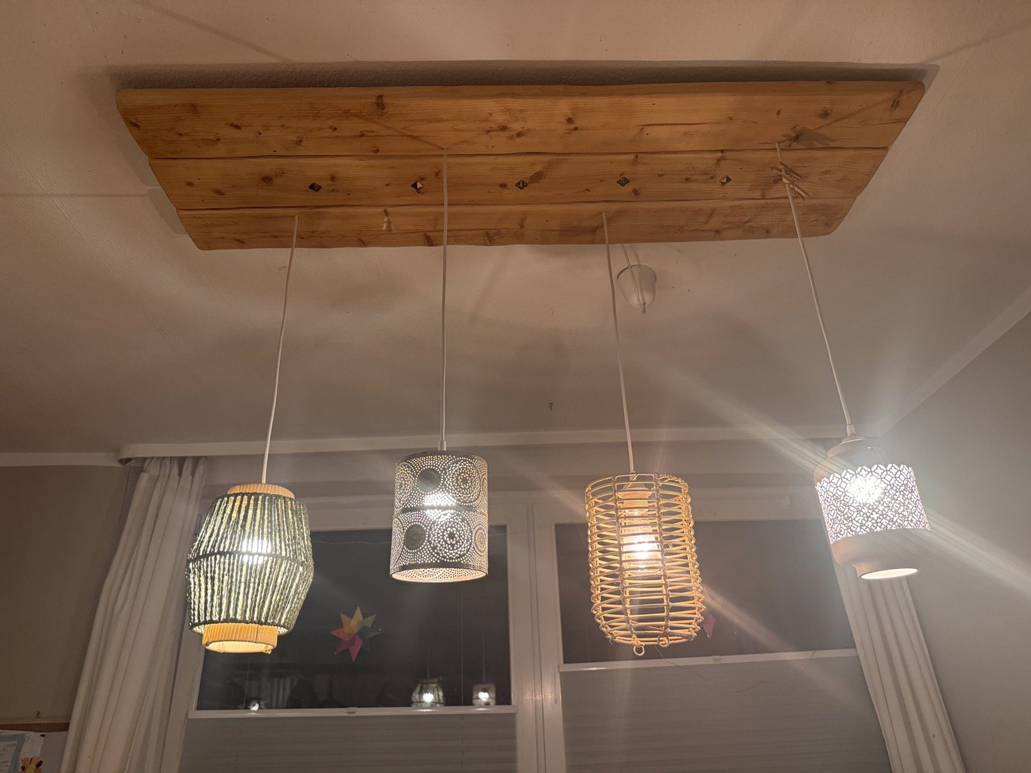Holzbrett an der Decke mit vier Hängeschirmen