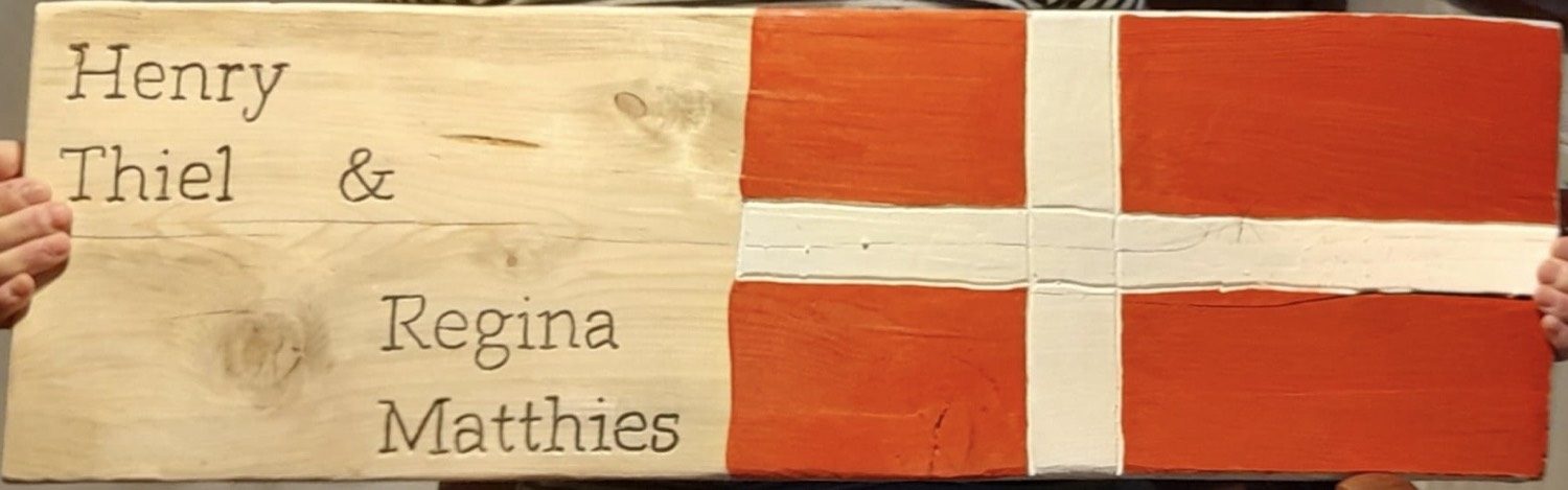 Holzbretter mit den Namen Henry Thiel und Regina Matthies und gemalter Dannebrog-Flagge